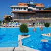 Piscina all'aperto con persone e sedie a sdraio.