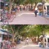 Una strada alberata con biciclette parcheggiate e persone che passeggiano.