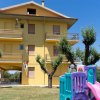 Edificio giallo con scivolo nel giardino.