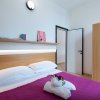 Camera da letto moderna con copriletto viola.