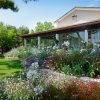 Giardino fiorito davanti a una casa con veranda.