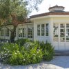 Edificio bianco con ampie finestre e fiori in giardino.