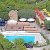 Vista aerea di un'area con piscina, edifici e alberi.