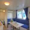 Sala interna con angolo cottura, tavolo e divano blu.