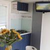 Cucina moderna con mobili blu, fiori di girasole sul tavolo e TV montata in alto.