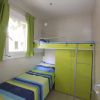 Cameretta con letto a castello e guardaroba verde.
