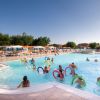 Persone in piscina con ciambelle colorate.