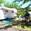 Camper con sedie e tavolo all'aperto.
