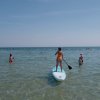 Persone in mare, paddleboard al centro.