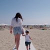 Donna e bambino camminano sulla spiaggia.