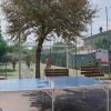 Due persone giocano a ping pong all'aperto.