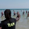 Istruttore conduce una lezione di acquagym al mare.