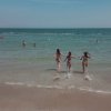Tre ragazze corrono verso il mare.