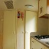 Cucina compatta con finestra, tavolo, e piano cottura.